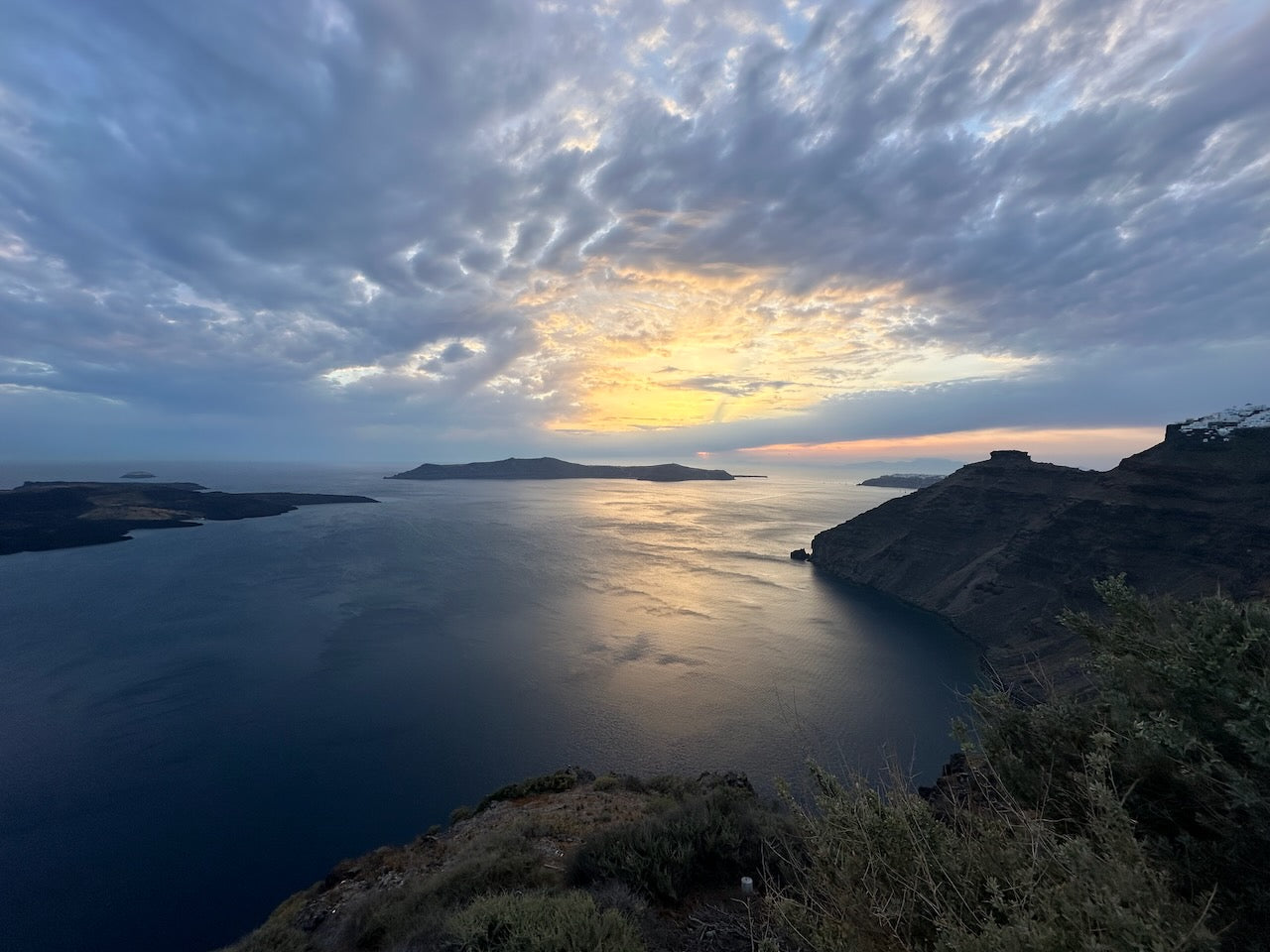 An iconic sunset over the caldera of Santorini and Thirasia.